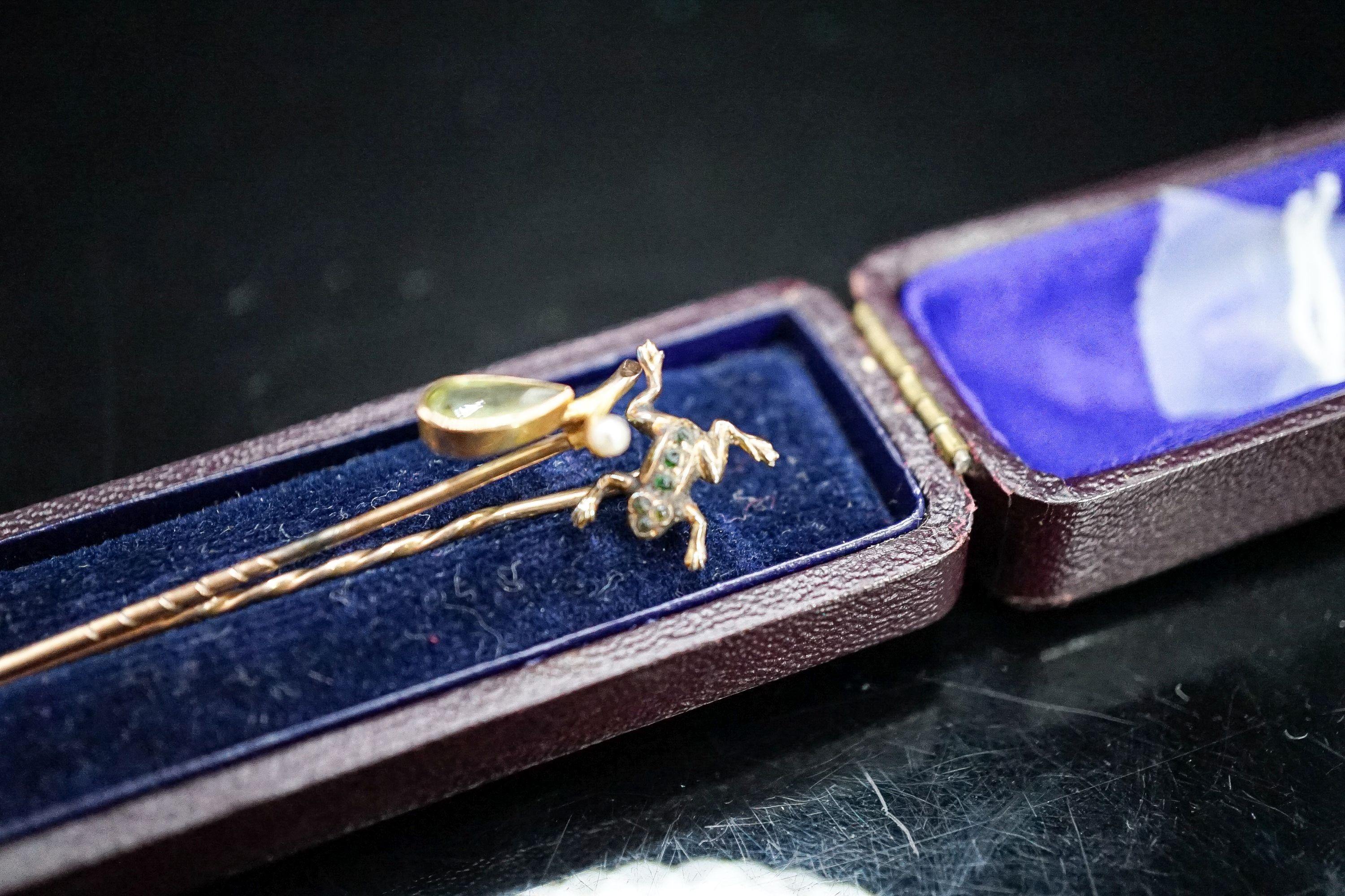 An early 20th century 9ct and gem set frog stick pin, stamped MB & Cie, 57mm and one other 9c and gem set stick pin, gross weight 2.2 grams.